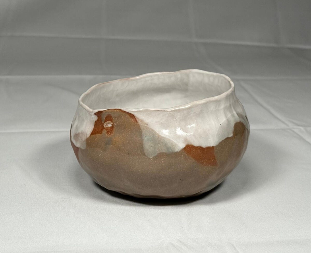 Organic bowl Dimpled, hand-built, light green glazed bowl by Shane Brodie. This wide, flat-bottomed bowl has a white liner glaze and red clay spots that were left unglazed.