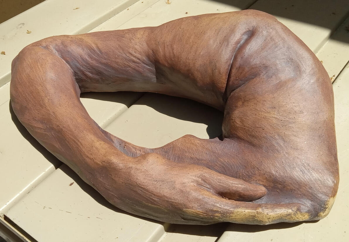 Comfort 2 Sculpture of an arm wrapping around and resting on the back of a neck by Shane Brodie. Surface texture shows gestural finger marks and is emphasized with iron oxide.